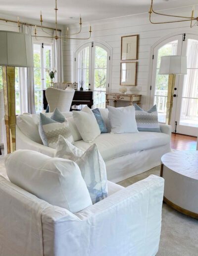A living room with white furniture and gold accents.